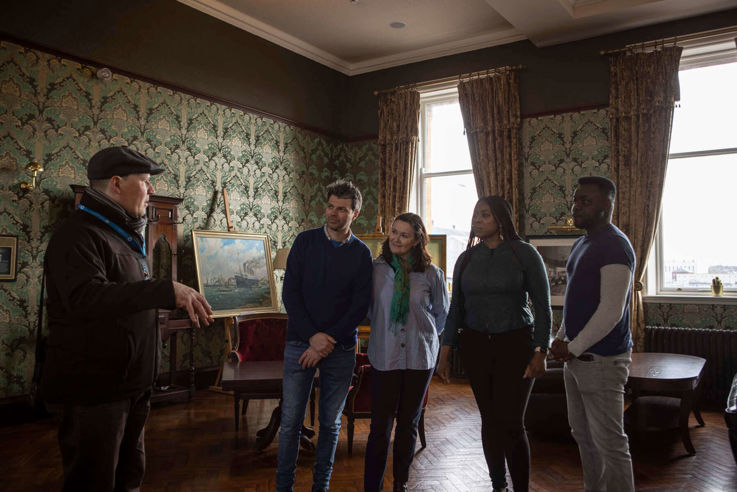 Tour Guide taking visitors through Titanic Hotel as part of the Lagan Legends Walking Tour