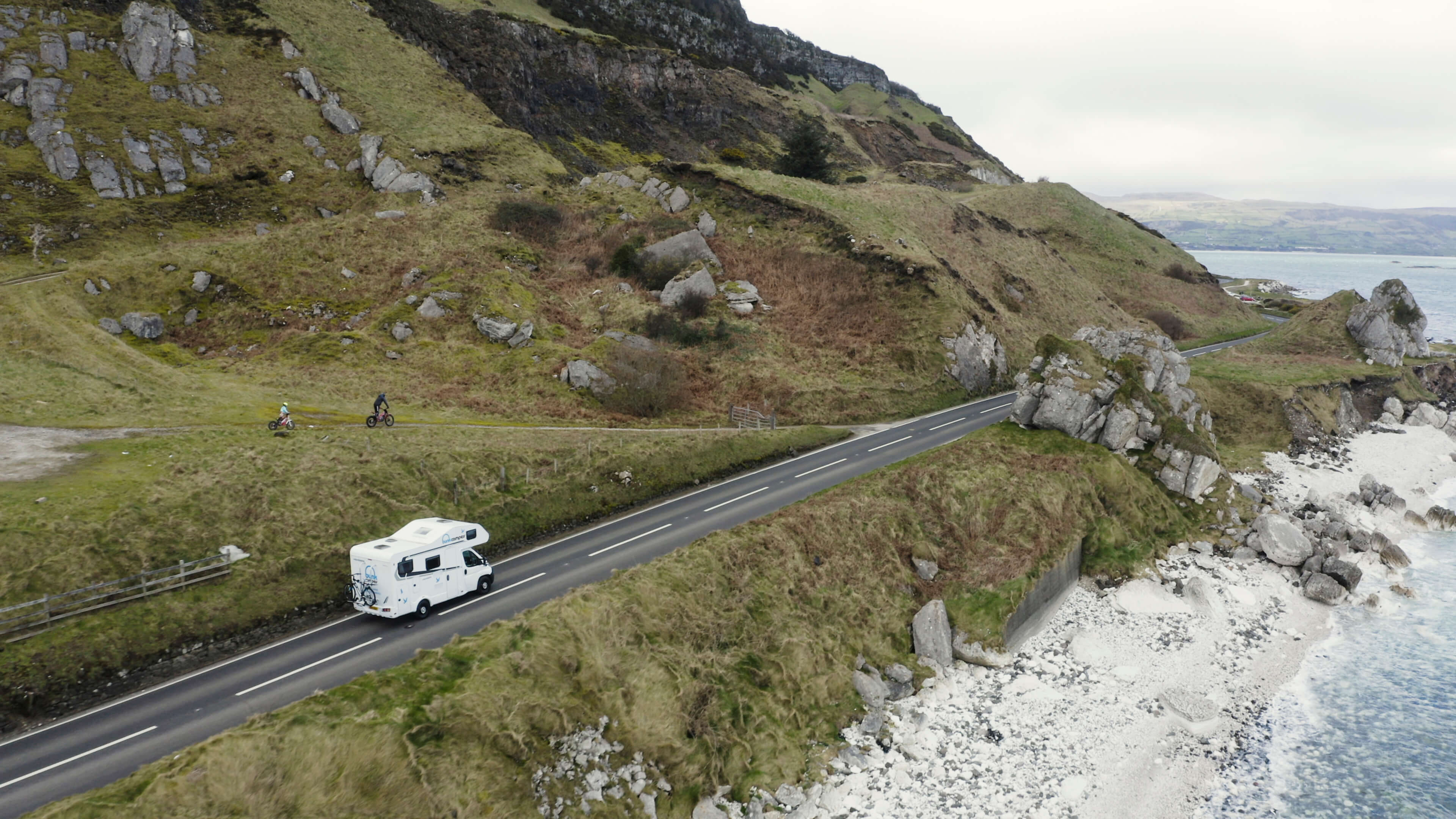 Camper van driving along a coastal road