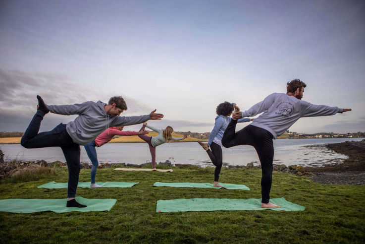 Friends in yoga pose with a view over Strangford Lough