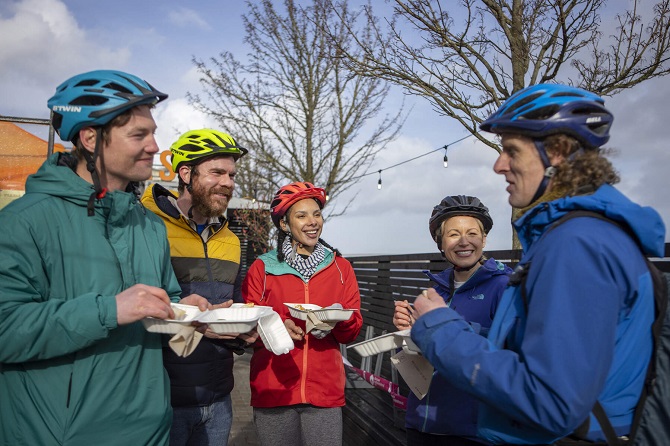 A group of visitors stop off for some delicious street food at Pyke and Pommes as part of the Far and Wild Foodie Cycling tour.